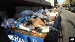 FILE - A dumpster filled with spoiled food waits for removal behind a Key Food supermarket in the still powerless East Village section of Manhattan, November 01, 2012, in New York.