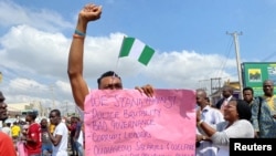 A demonstrator carries a banner during a protest demanding police reform in Lagos, Nigeria, Oct. 20, 2020. 
