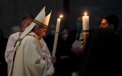Pope Francis celebrates the Easter Vigil in a nearly empty St. Peter's Basilica as coronavirus pandemic restrictions stay in place for a second year running, at the Vatican, April 3, 2021. (Remo Casilli/Pool photo via AP)