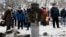 People look at the remains of a rocket shell on a street in the town of Kramatorsk, eastern Ukraine, Feb. 10, 2015. T 