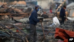A man walks through the scorched ground of the open-air San Pablito fireworks market, in Tultepec, outskirts of Mexico City, Mexico, Dec. 20, 2016.