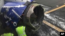 The engine on a Southwest Airlines plane is inspected as it sits on the runway at the Philadelphia International Airport after it made an emergency landing in Philadelphia, April 17, 2018.