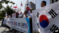 South Korean protesters shout slogans as they hold national flags during a press conference against abrupt cancellation by North Korea of planned reunions for families separated by the Korean War, Sept. 23, 2013.