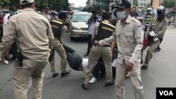 រូបឯកសារ៖ កង​សន្តិសុខខណ្ឌ៧មករា​ក្នុងទីក្រុងភ្នំពេញ​ ចាប់អូស​ទាញអ្នក​តវ៉ា​ចេញពី​ច្រកទ្វារ​សាលាដំបូង​រាជធានីភ្នំពេញ ថ្ងៃទី​២៤​ ខែកក្កដា​ ឆ្នាំ​២០២០។ (ហ៊ុល​ រស្មី/វីអូអេ)