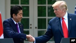 President Donald Trump and Japanese Prime Minister Shinzo Abe shakes hands during a news conference in the Rose Garden of the White House in Washington, June 7, 2018.