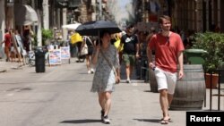 چتری برای پناه گرفتن از آفتاب سوزان - پالرمو، ایتالیا، ۲۸ تیر ۱۴۰۲