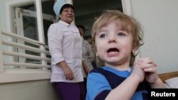 A Buddhist monk and villagers examine a damaged Buddha statue following an earthquake in Chiang Rai province, northern Thailand.