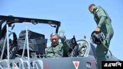 The 27th Chief of Army Staff of the Indian Army Bipin Rawat (L) waves after sitting in the co-pilot seat of a Light Combat Aircraft of the Indian Airforce during the Aero India airshow at the Yelahanka Air Force station, in B angalore on February 21, 2019. 