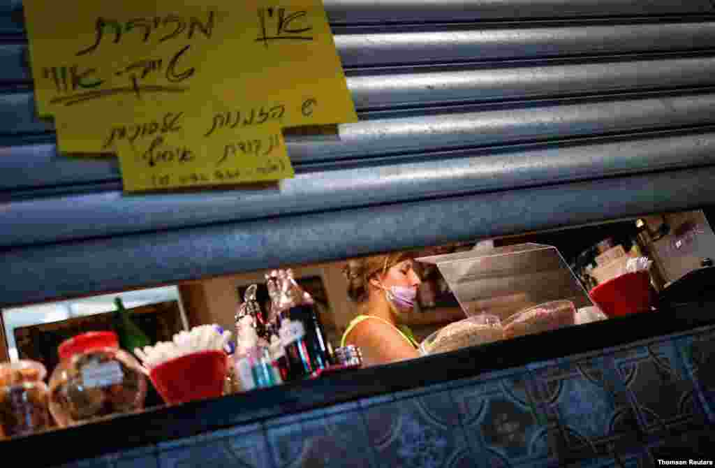 신종 코로나바이러스 재확산으로 3차 전국 봉쇄에 들어간 이스라엘 텔아비브에서 한 식당 종업원이 식당 문을 닫을 준비를 하고 있다. 