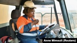 Tene Konate, 42, a truck driver, talks on a radio as she sits in her truck at the gold mine site, operated by Endeavour Mining Corporation in Hounde, Burkina Faso February 10, 2020. (Reuters/Anne Mimault)