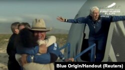 Miliarder Jeff Bezos dan perintis penerbang perempuan, Wally Funk, keluar dari wahana antariksa setelah penerbangan ke antariksa dengan roket New Shepard milik Blue Origin, dekat Van Horn, Texas, 20 Juli 2021.