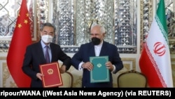 资料照片：中国外长王毅和伊朗外长扎里夫在德黑兰签署25年的合作协议（2021年3月27日）