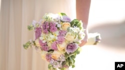 In this Thursday, Dec. 14, 2017 photo, a bride holds a bouquet during her wedding in Ein Hemed. A growing number of Israeli couples are defying the country’s Chief Rabbinate and marrying in unsanctioned weddings. The couples include people who have…