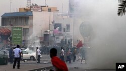 Riot police fire tear gas to prevent Bahraini anti-government protesters from marching toward the hub of last spring's pro-democracy uprising at the end of a mass rally just outside Manama, April 20, 2012.