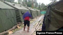 FILE - An undated photo from the Refugee Action Coalition on Feb. 18, 2014, shows a man walking between tents at Australia's regional processing center on Manus Island in Papua New Guinea. 