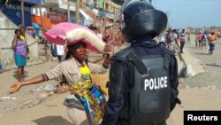 신종 코로나바이러스 감염증(COVID-19) 확산 방지를 위해 전국 봉쇄령이 내려진 리베리아 몬로비아에서 경찰이 지난 11일 거리에 모여 있는 주민들을 해산시키고 있다.