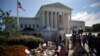  A woman puts flower on a memorial altar as people gather in front of the U.S. Supreme Court following the death of U.S. Supreme Court Justice Ruth Bader Ginsburg, in Washington, U.S., September 19, 2020. REUTERS/Carlos Barria