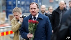 Le Premier ministre Stefan Lofven, bouquet de fleurs en main, arrive sur le lieu d'un attentat au camion-bélier à Stockholm, Suède, 8 avril 2017.