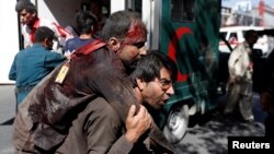 An Afghan man carries an injured man to a hospital after a blast in Kabul, Afghanistan May 31, 2017. (REUTERS/Mohammad Ismail )