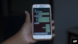 In this Monday, June 15, 2020 photo, Rafaela Matos shows the last text messages from her son João Pedro Matos Pinto, at her home in Sao Goncalo, Brazil. (AP Photo/Silvia Izquierdo)