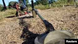 FILE - A deminer works near a metal detector at a testing area in a minefield during a demonstration to the media at the Demining Center in Kampong Speu province, Nov. 27, 2011. 