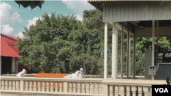Workers in PPE move the body of a covid-19 patient to a cremation area, at Tuek Thla pagaoda, Phnom Penh, on August 18, 2021. (Thida Win/VOA Khmer) 