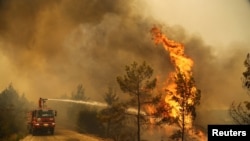 Seorang petugas memadamkan kebakaran hutan di dekat kota Manavgat, sebelah timur kota resor Antalya, Turki, 30 Juli 2021. (Foto: REUTERS/Kaan Soyturk)