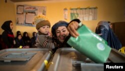 An Afghan woman casts her ballot at a polling station in Mazar-i-sharif, Apr. 5, 2014. 