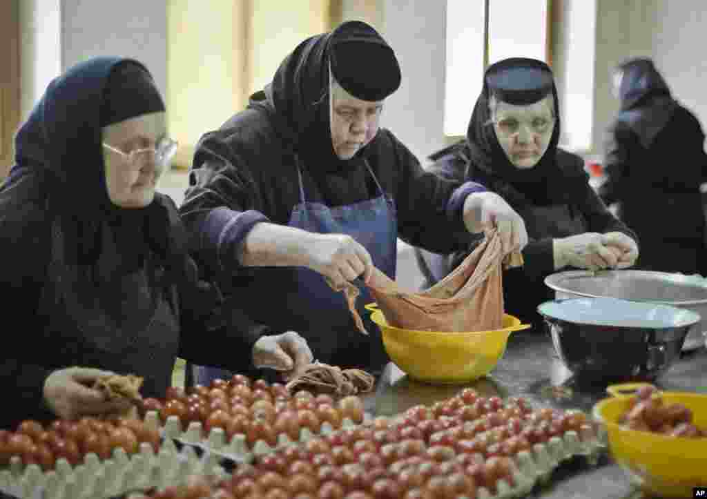 An Orthodox nun handles colored eggs at the Timiseni Monastery, outside Sag, western Romania, April 18, 2014.&nbsp;