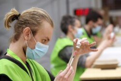 Petugas medis menyiapkan dosis vaksin COVID-19 Oxford/AstraZeneca di pusat vaksinasi di Antwerpen, Belgia, 18 Maret 2021.