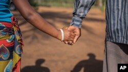  A 15-year-old pregnant girl holds hands with her 20-year-old husband-to-be in Guibombo, some 40 kilometers from the city of Inhambane, Mozambique,Nov. 18, 2015.