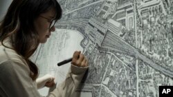 Chinese artist Yang Qian using dots to recreate an aerial view of Wuhan, China, under lockdown at her studio in Wuhan in central China's Hubei province on Sunday, Jan. 24, 2021. (AP Photo/Ng Han Guan)