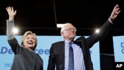 Democratic presidential candidate Hillary Clinton and Sen. Bernie Sanders, I-Vt., take the stage during a campaign stop at the University Of New Hampshire in Durham, N.H., Wednesday, Sept. 28, 2016.
