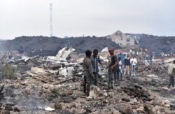 Residents pick up remains of their destroyed homes from the smouldering lava deposited by the eruption of Mount Nyiragongo volcano near Goma, Democratic Republic of Congo, May 23, 2021.