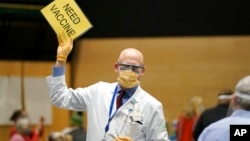 រូបឯកសារ៖ លោកវេជ្ជបណ្ឌិត John Corman នៃ​មណ្ឌល​សុខភាព Virginia Mason Franciscan Health កាន់​ក្រដាស​មួយ​ដែល​មាន​សំណេរ​ថា «ត្រូវការវ៉ាក់សាំង» ដើម្បី​ផ្តល់​សញ្ញា​ដល់​បុគ្គលិក ឲ្យ​យក​វ៉ាក់សាំង​បង្ការ​ជំងឺ​កូវីដ​១៩ បន្ថែម​ទៀត​មក​ឲ្យ​លោក កាលពី​ថ្ងៃទី១៩ ខែមករា ឆ្នាំ២០២១។