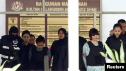 Doan Thi Huong (Vietnam) dan Siti Aisyah (Indonesia) yang diadili atas tuduhan terlibat dalam pembunuhan Kim Jong-nam, saudara tiri pemimpin Korea Utara, dikawal ketat saat meninggalkan Pengadilan Tinggi Shah Alam di pinggiran Kuala Lumpur, Malaysia, 3 Oktober 2017. (Foto: dok).