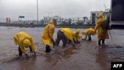 Petugas kebersihan kota mengumpulkan ranting-ranting dari jalanan yang tergenang banjir akibat hantaman badai Patricia, di Manzanillo, negara bagian Colima, Meksiko (23/10).