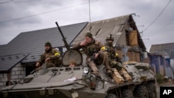 Tentara Ukraina mengendarai kendaraan militer lapis baja di pinggiran Kyiv, Ukraina, Sabtu, 5 Maret 2022. (Foto: AP/Emilio Morenatti)