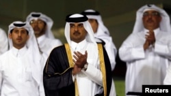 Qatar's Crown Prince Sheikh Tamim bin Hamad al-Thani (C) attends a soccer match at al-Sadd Stadium in Doha, May 4, 2013.