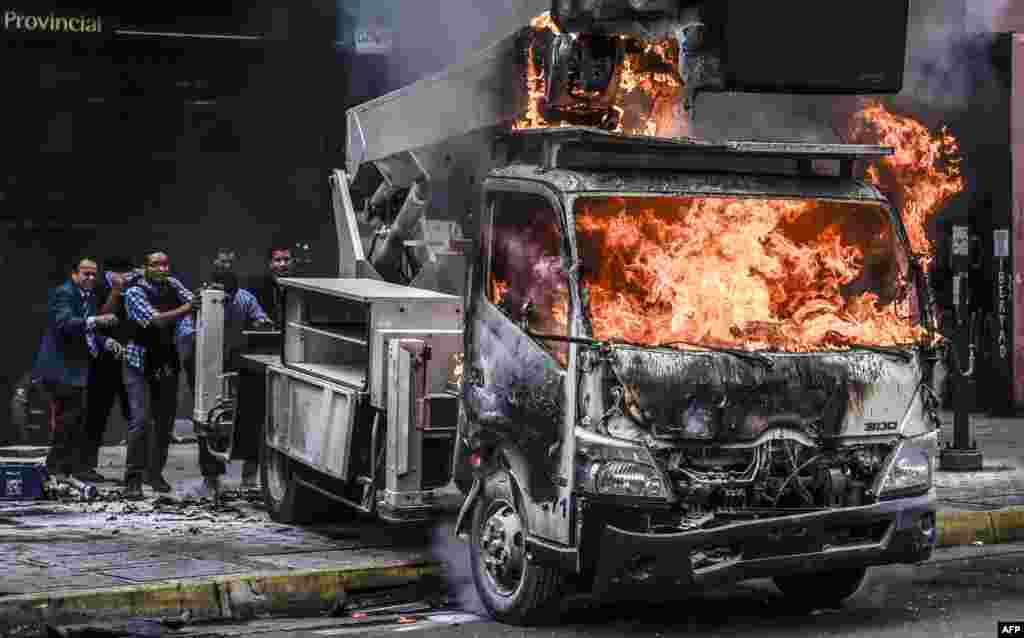 Supreme Justice Court (TSJ) workers push a truck set ablaze by protesters away from the premises during clashes between riot police and opposition activists to protest against the government of President Nicolas Maduro in Caracas, Venezuela, June 7, 2017.