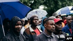 Les employés et sous-traitants de l'Optimum Coal Mine à Hendrina, écoutent le PDG de l'entreprise devant les portes de la mine de Hendrina, en Afrique du Sud, le 22 février 2018