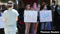 People hold signs thanking healthcare workers outside UCLA hospital, as the global outbreak of coronavirus disease (COVID-19) continues, in Los Angeles