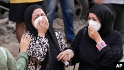 Women react in front of their destroyed apartment at the site an Israeli airstrike in Beirut, Lebanon, Oct. 11, 2024. 