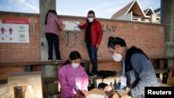 FILE - Members of the jury prepare a polling station before the presidential election in La Paz, Bolivia, Oct. 18, 2020. (Reuters)
