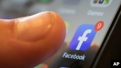 Layar telepon genggam menampilkan logo media sosial Facebook dalam foto ilustrasi yang diambil pada 11 agustus 2019. (Foto: AP/Jenny Kane)