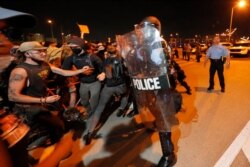 FILE - Protesters breach a line of police atop the Crescent City Connection bridge, which spans the Mississippi River in New Orleans, June 3, 2020, during a protest over the death of George Floyd.