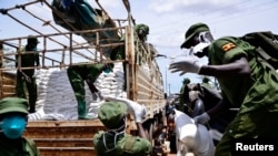 Members of Local Defense Unit (LDU) unload relief food to civilians who are affected by the lockdown to prevent the potential spread of coronavirus, in Kampala, Uganda, April 4, 2020. 