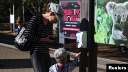 Para pengunjung menggunakan penyanitasi tangan sebelum masuk ke Kebun Binatang Taronga Sydney yang buka kembali menyusul pelonggaran pembatasan terkait waba virus corona (Covid-19), Sydney, Australia, 1 Juni 2020. (Foto: Reuters)