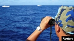 រូបឯកសារ៖ មន្រ្តីកងល្បាតនាវាមើលទៅនាវាកងល្បាតចិន នៅតំបន់សមុទ្រចិនខាងត្បូង កាលពីថ្ងៃទី១៥ ខែកក្កដា ឆ្នាំ២០១៤។ 