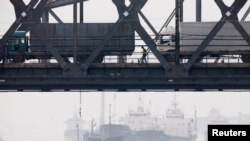 북한 신의주에서 중국 단둥으로 향하는 화물차들이 '조중친선다리(중조우의교)' 위로 압록강을 건너고 있다. (자료사진)